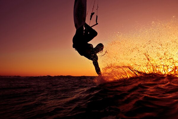 Surfista salto sullo sfondo del tramonto