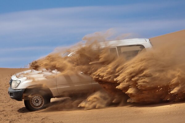 Coche blanco en el desierto de arena