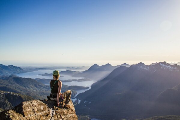 Mädchen sitzt auf dem Hintergrund der Berge