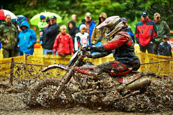 Sportler auf einem Motorrad fährt im Schlamm