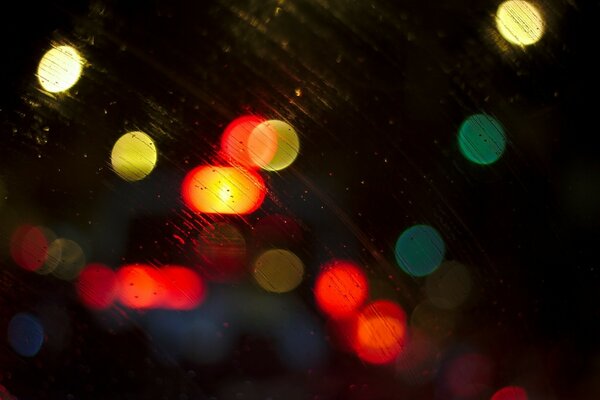 Dans la rue sous la pluie, les phares de la voiture brillent