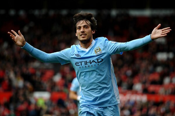 Footballer David Silva runs with his arms outstretched