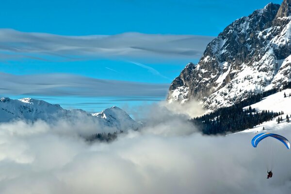 Paracadute sullo sfondo di montagne e nuvole