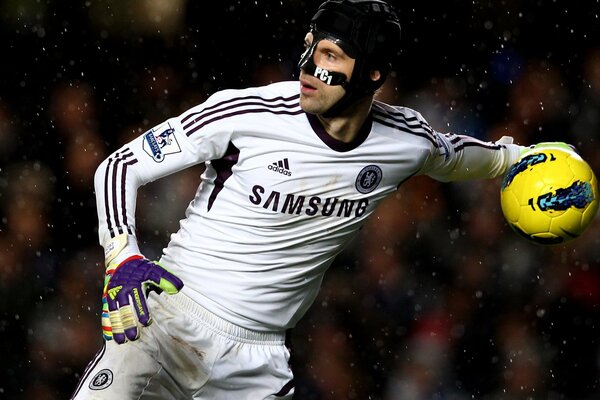 The goalkeeper in the mask catches the ball