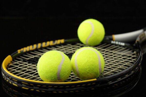 A racket and three tennis balls