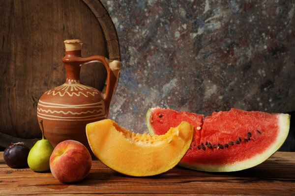 Still life with watermelon and melon. A slice of watermelon. A slice of melon. Fresh fruit. A jug of wine