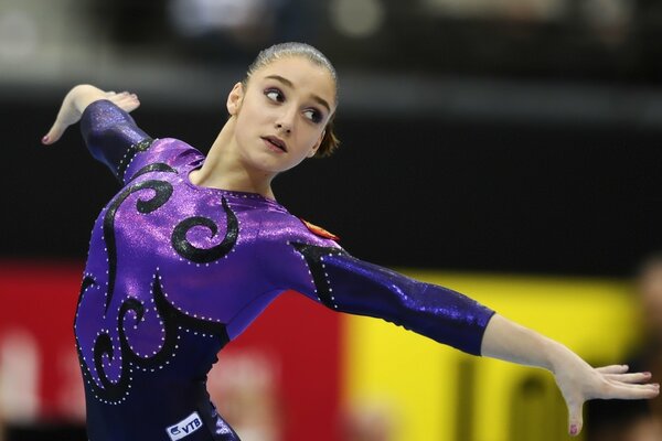 Gymnastics at a performance in a black and purple suit