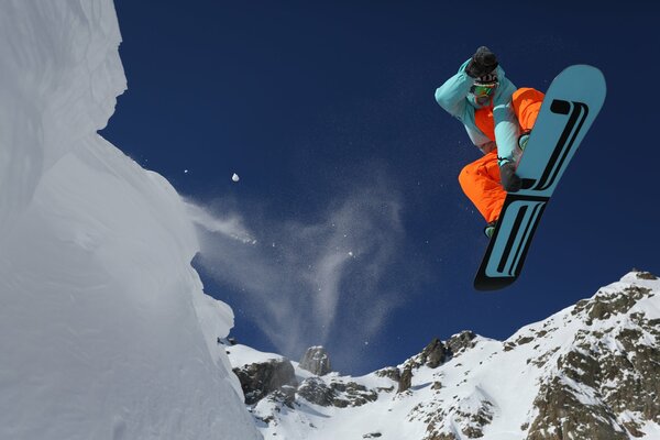 Snowboarder im Sprung vor dem Hintergrund der Berge