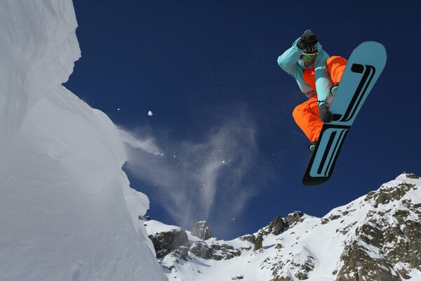 Snowboarder jumping on the background of mountains