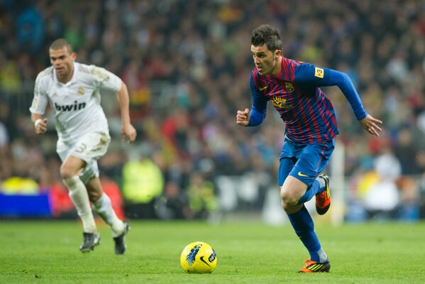 Dos futbolistas en movimiento frente a la pelota