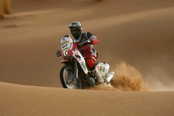 Motocycliste sur fond de dunes de sable