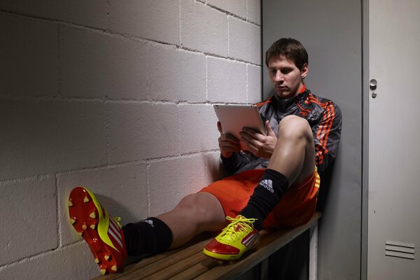 Lionel Messi is playing football in uniform on the bench