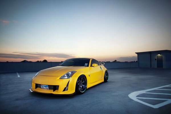 Yellow tuned nissan on the background of the evening sky