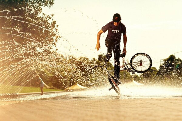 Acrobazia in bicicletta vicino alla fontana