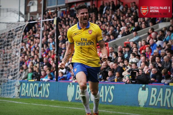 A football player of the Arsenal football club on the background of the stands with fans