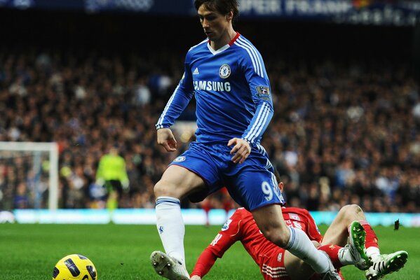 Footballer Torres rolls the ball on the field