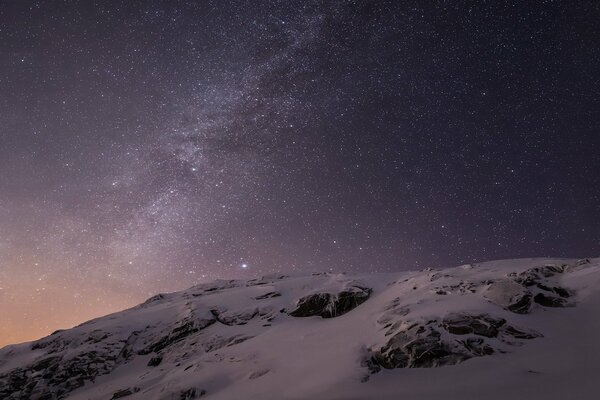 Foto di cielo stellato e montagne innevate