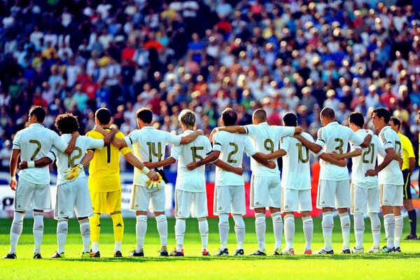 Команда Реал Мадрид слушает гимн перед футбольным матчем