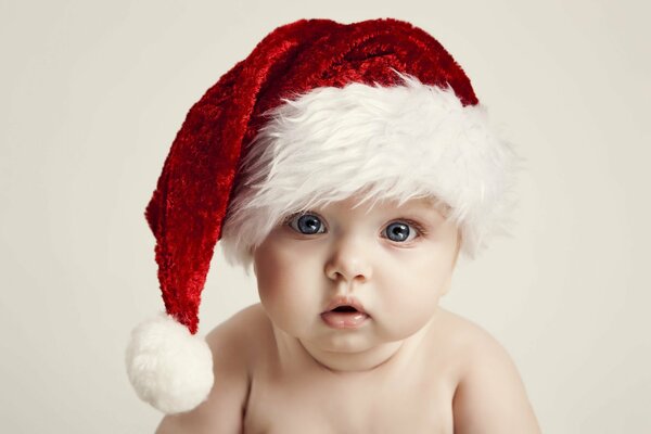 Święta noworoczne Nowy Rok i Boże Narodzenie, szczęśliwe dziecko z dużymi niebieskimi oczami