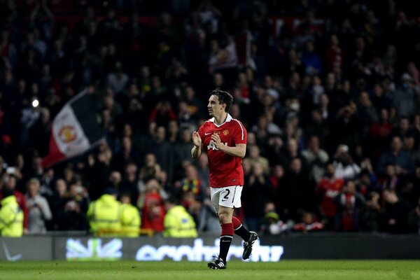 A football player runs across the field applauding