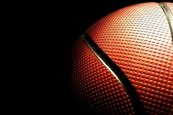 Фактурная поверхность баскетбольного мяча в темноте