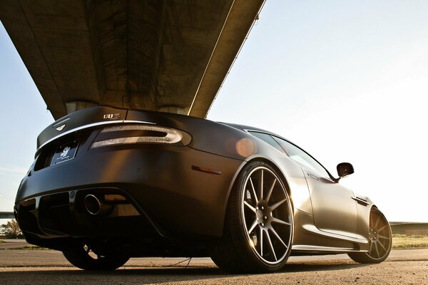 Brown supercar under the bridge foreshortening from below