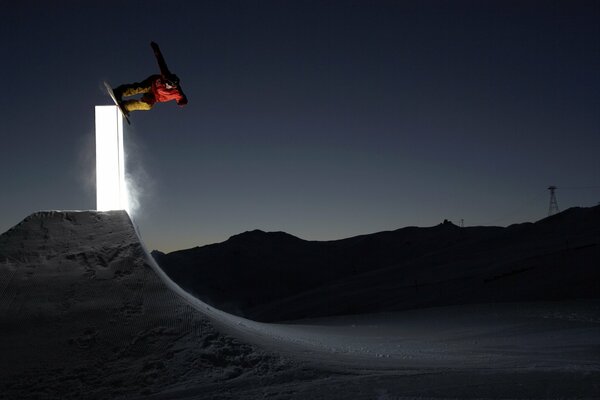 Skispringen auf einem Snowboard in einer ruhigen Winternacht