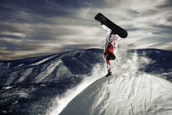 Der Trick eines Snowboarders auf einem schneebedeckten Gipfel