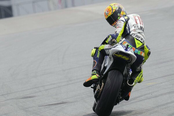 Fotograma de un motociclista en moto girado hacia atrás