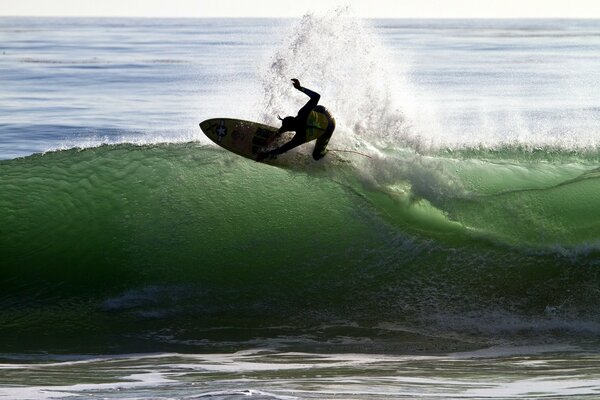 A huge green wave. Athlete on the board