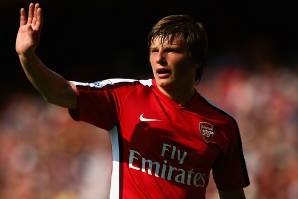 Arshavin dans un t-shirt rouge agite sa main