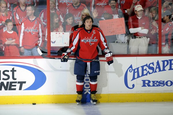 A hockey player in a red uniform with a stick in his hands