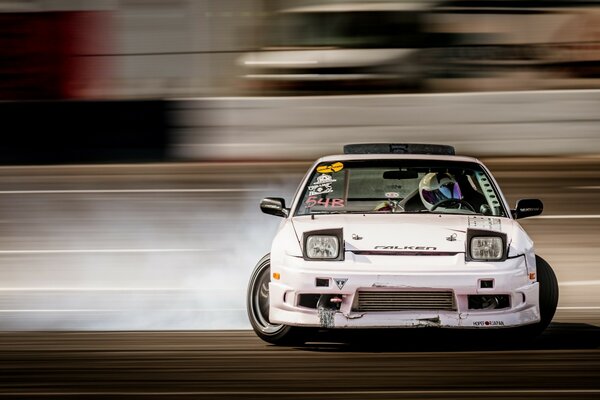 The racer drifts, the smoke from the tires