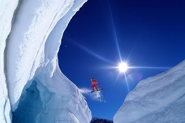 Snowboarder volant entre les montagnes enneigées