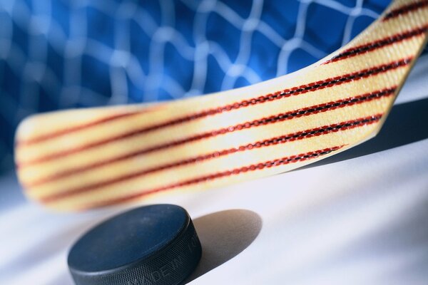 A stick with an ornament hits the puck