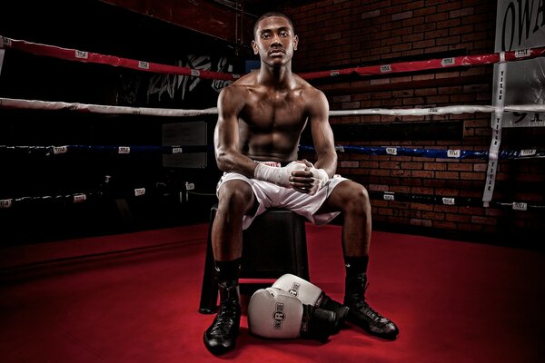 Athlète noir assis sur une chaise dans le Ring