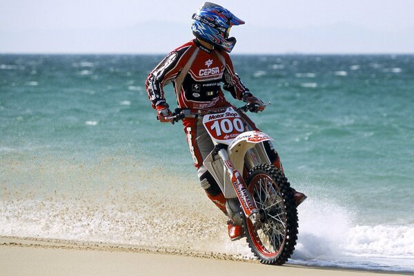 Biker on a motorcycle on the sandy coast