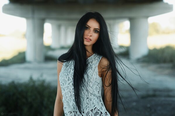 Fille brune avec de longs cheveux sous le pont