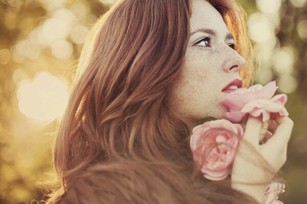 Ragazza con lentiggini estive con fiori in mano