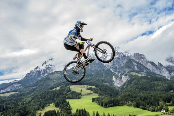 Salto en bicicleta en el fondo de las montañas