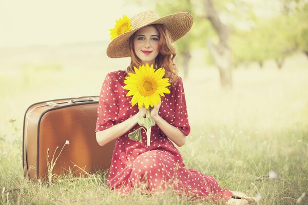 A girl with a suitcase in a clearing