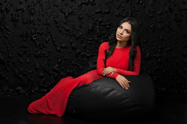 Model Arevik Voskanyan in a red dress on a black background