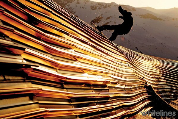 Silhouette of a snowboarder on a golden texture