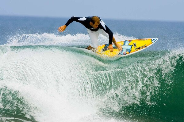 Surfeur sur la crête de la vague turquoise