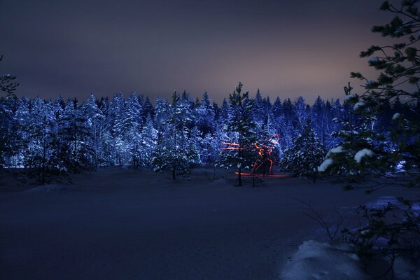 The silhouette of a lyuzhnik in the forest on a winter night