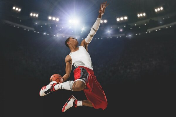 Ein Mann in einer rot-weißen Sportuniform mit einem Basketballball