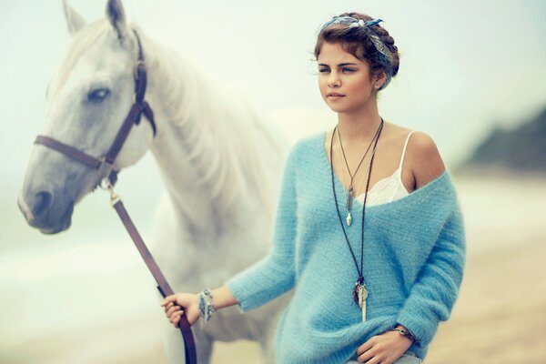 Fille marche avec un cheval sur la plage de la mer