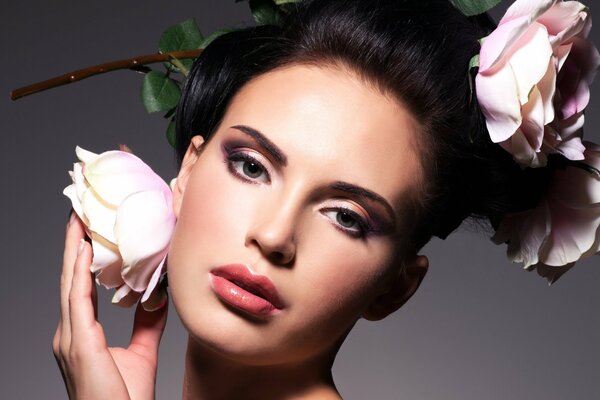 Photo of a girl s face with evening makeup and roses