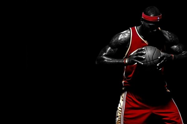 LeBron James clutching the ball tightly on a black background