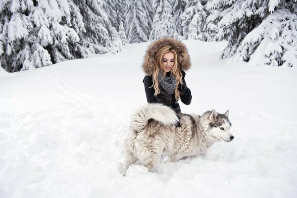 Blonde with a dog in the winter forest